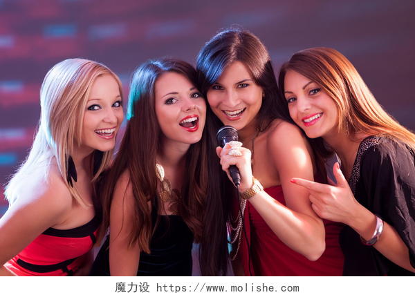 在俱乐部唱的时尚女孩四个美丽的女孩唱卡拉 ok